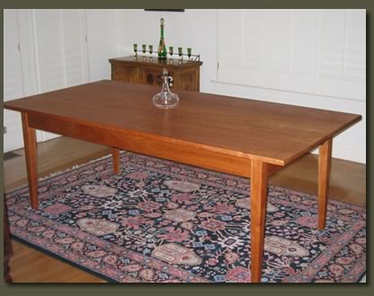 Our custom made Cherry Dining Table is both elegant and functional, designed with classic lines, tapered legs, beaded aprons, and a small drawer