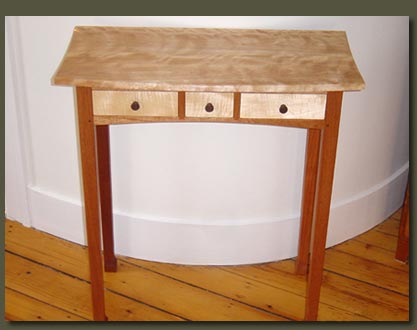 A figured red birch top, long mahogany legs, and extensive curves provide the visual punch for our 3 Drawer Spider Table